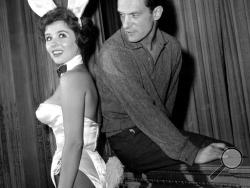 In this June 20, 1961 file photo, Playboy magazine publisher Hugh Hefner poses with "bunny-girl" hostess Bonnie J. Halpin at Hefner's nightclub in Chicago. Playboy founder and sexual revolution symbol Hugh Hefner has died at age 91. The magazine released a statement saying Hefner died at his home in Los Angeles of natural causes on Wednesday night, Sept. 27, 2017, surrounded by family. (AP Photo/Ed Kitch, File)