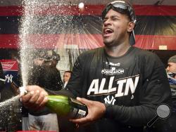 New York Yankees starting pitcher Luis Severino sprays sparkling wine in the locker room the Yankees defeated the Cleveland Indians 5-2 in Game 5 of a baseball American League Division Series, early Thursday, Oct. 12, 2017, in Cleveland. The Yankees advanced to the ALCS. (AP Photo/David Dermer)