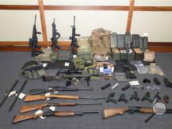This image provided by the U.S. District Court in Maryland shows a photo of firearms and ammunition that was in the motion for detention pending trial in the case against Christopher Paul Hasson. Prosecutors say that Hasson, a Coast Guard lieutenant is a "domestic terrorist" who wrote about biological attacks and had a hit list that included prominent Democrats and media figures. He is due in court on Feb. 21 in Maryland. Prosecutors say Hasson espoused extremist views for years. Court papers say Hasson des