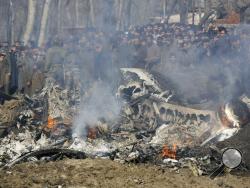 Kashmiri villagers gather near the wreckage of an Indian aircraft after it crashed in Budgam area, outskirts of Srinagar, Indian controlled Kashmir, Wednesday, Feb.27, 2019. (AP Photo/Mukhtar Khan)