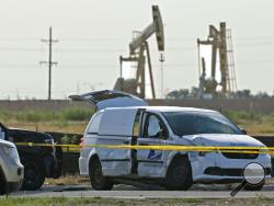A U.S. Mail vehicle, right, which was involved in Saturday's shooting, is pictured outside the Cinergy entertainment center Sunday, Sept. 1, 2019, in Odessa, Texas. The death toll in the West Texas shooting rampage increased Sunday as authorities investigated why a man stopped by state troopers for failing to signal a left turn opened fire on them and fled, shooting over a dozen people as he drove before being killed by officers outside a movie theater. A police vehicle is partially blocked at left. (AP Pho