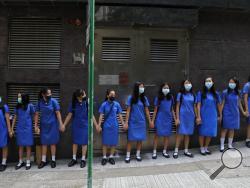 Students wearing masks hold hands to surround St. Stephen's Girls' College in Hong Kong, Monday, Sept. 9, 2019. Thousands of demonstrators in Hong Kong urged President Donald Trump to "liberate" the semiautonomous Chinese territory during a peaceful march to the U.S. Consulate on Sunday, but violence broke out later in the business and retail district as police fired tear gas after protesters vandalized subway stations, set fires and blocked traffic. (AP Photo/Kin Cheung)