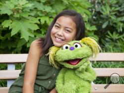 This undated image released by Sesame Workshop shows 10-year-old Salia Woodbury, whose parents are in recovery, with "Sesame Street" character Karli. Sesame Workshop is addressing the issue of addiction. Data shows 5.7 million children under 11 live in households with a parent with substance use disorder. Karli had already been introduced as a puppet in foster care earlier this year but viewers now will understand why her mother had to go away for a while. (Flynn Larsen/Sesame Workshop via AP)