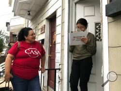Mirna Orellana, left, a community organizer from the non-profit group We Are Casa, helps Karyme Navarro, right, fill out a voter registration form in York, Pa., on Sept. 30, 2019. Democrats are counting on Hispanics so enraged by President Donald Trump’s anti-immigrant rhetoric that they’ll turn out in force to deny him a second term, but Trump’s reelection campaign has launched its own Hispanic outreach efforts in non-traditional places like Pennsylvania, arguing that even slim gains could decide the 2020 
