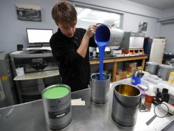 Harvey Myland prepares paint for mixing at the factory in London, Thursday, Oct. 24, 2019. Founded 135 years ago, Mylands paint factory has survived two World Wars, and now supplies film and TV productions such as ``Harry Potter'' and ``Game of Thrones,'' but Brexit is already reshaping business decisions as they increase storage and moved extra stocks to Germany. (AP Photo/Frank Augstein)