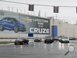 FILE - In this Nov. 27, 2018, file photo a banner depicting the Chevrolet Cruze model vehicle is displayed at the General Motors' Lordstown plant in Lordstown, Ohio. An economic renaissance in the industrial Midwest promised by President Donald Trump has suffered in recent weeks in ways that could be problematic for Trump's 2020 re-election. (AP Photo/John Minchillo, File)