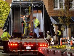 Workers load a Confederate statue onto a truck after it was removed from its spot in front of the historic Chatham County courthouse in Pittsboro, N.C. early Wednesday, Nov. 20, 2019. (Scott Sharpe/The News & Observer via AP)