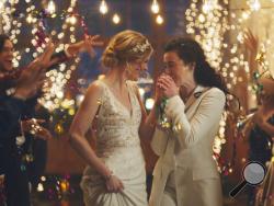 This image made from undated video provided by Zola shows a scene of its advertisement. The Hallmark Channel says it will reinstate same-sex marriage commercials that it had pulled from the network. Hallmark Cards CEO Mike Perry said in a statement Sunday, Dec. 15, 2019, that pulling the commercials “was the wrong decision." (Zola via AP)