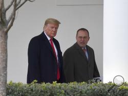In this Jan. 13, 2020. file photo, President Donald Trump, left, and acting White House chief of staff Mick Mulvaney, right, walk along the colonnade of the White House in Washington. The federal government's watchdog agency says a White House office violated federal law in withholding security assistance to Ukraine aid. The Government Accountability Office said Thursday the White House Office of Management and Budget violated the law in holding up the assistance. (AP Photo/Susan Walsh, File)
