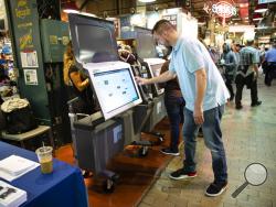 FILE - In this June 13, 2019, file photo, Steve Marcinkus, an Investigator with the Office of the City Commissioners, demonstrates the ExpressVote XL voting machine at the Reading Terminal Market in Philadelphia.