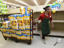 Abraham Ortiz, an employee at Market Basket in Johnstown, Pa., stocks paper towels and toilet paper, Saturday, March 14, 2020. Those items, along with tissues, anti-bacterial soap and hand sanitizer, are selling exponentially faster than normal due to the nation-wide panic over the coronavirus. (John Rucosky/The Tribune-Democrat via AP)