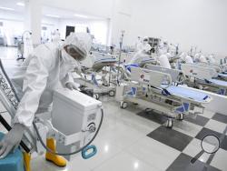 Staff inspect medical equipments at an emergency hospital set up amid the new coronavirus outbreak in Jakarta, Indonesia, Monday, March 23, 2020. Indonesia has changed towers built to house athletes in the 2018 Asian Games to emergency hospitals with a 3,000-bed capacity in the country's hard-hit capital, where new patients have surged in the past week. (Hafidz Mubarak A/Pool Photo via AP)