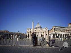 A man stands in front of St. Peter's Square and Basilica during Pope Francis' weekly general audience, streamed by the Vatican television due to restrictions to contain the Covid-19 virus, at the Vatican, Wednesday, April 1, 2020. The new coronavirus causes mild or moderate symptoms for most people, but for some, especially older adults and people with existing health problems, it can cause more severe illness or death. (AP Photo/Andrew Medichini)