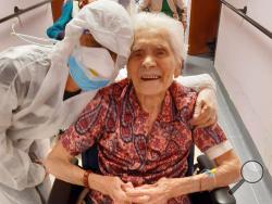 In this photo taken on April 1, 2020, 103-year-old Ada Zanusso, poses with a nurse at the old people's home "Maria Grazia" in Lessona, northern Italy, after recovering from Covid-19 infection. To recover from coronavirus infection, as she did, Zanusso recommends courage and faith, the same qualities that have served her well in her nearly 104 years on Earth. The new coronavirus causes mild or moderate symptoms for most people, but for some, especially older adults and people with existing health problems, i