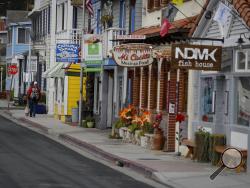 A resident walks down a empty street on Catalina Island in Avalon, Calif, Saturday, April 18, 2020, In the weeks that the city's normally bustling Two Harbors port has been closed due to the COVID-19 outbreak, Mayor Ann Marshall estimates the harbor alone has lost nearly $2 million in business. (AP Photo/Chris Carlson)