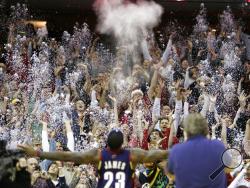 FILE - In this Dec. 25, 2008, file photo, fans toss confetti to mimic Cleveland Cavaliers' LeBron James's pre-game chalk toss before an NBA basketball game against the Washington Wizards in Cleveland. Billions has been spent on state-of-the-art sports facilities over the last quarter-century, but there is no way to prevent the potential spread of a virus through coughing or sneezing. Officials are working on safety protocols and looking at new technology in hopes of making stadiums and arenas as safe as the