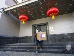 A FedEx employee removes a box from the Chinese Consulate Thursday, July 23, 2020, in Houston. China says “malicious slander" is behind an order by the U.S. government to close its consulate in Houston, and maintains that its officials have never operated outside ordinary diplomatic norms. (AP Photo/David J. Phillip)