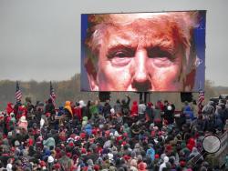FILE - In this Oct. 27, 2020, file photo, supporters of President Donald Trump watch a video during a campaign event in Lansing, Mich. (Nicole Hester/Mlive.com/Ann Arbor News via AP, File)