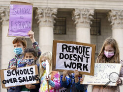 FILE - In this Nov. 14, 2020 file photo, students demonstrate during a rally to call on New York Mayor Bill de Blasio to keep schools open. Classroom doors will open for elementary school students next week, but middle school and high school students in New York City won't return to in-person learning until after the holiday break, De Blasio said Monday, Nov 30. (AP Photo/Mary Altaffer, File)