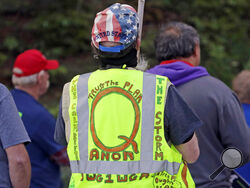 FILE - In this May 14, 2020, file photo, a person wears a vest supporting QAnon at a protest rally in Olympia, Wash., against Gov. Jay Inslee and Washington state stay-at-home orders made in efforts to prevent the spread of the coronavirus. President Joe Biden's inauguration has sown a mixture of anger, confusion and disappointment among believers in the baseless QAnon conspiracy theory. (AP Photo/Ted S. Warren, File)