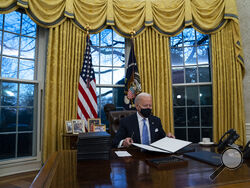 FILE - In this Jan. 20, 2021, file photo President Joe Biden signs a series of executive orders in the Oval Office of the White House in Washington. (AP Photo/Evan Vucci, File)