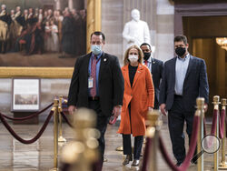 On the eve of the second impeachment trial of former President Donald Trump, Rep. Madeleine Dean, D-Pa., one of the Democratic House impeachment managers, is escorted by security through the Rotunda after preparing for the case in the Senate, at the Capitol in Washington, Monday, Feb. 8, 2021. The trial will begin Tuesday with a debate and vote on whether it's even constitutional to prosecute the former president, an argument that could resonate with Republicans keen on voting to acquit Trump. (AP Photo/J. 