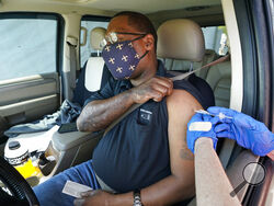 Brian Snipes receives a drive-thru vaccination Monday, March 29, 2021, at "Vaccine Fest," a 24-hour COVID-19 mass vaccination event in Metairie, La., just outside New Orleans, hosted by Ochsner Health System and the Jefferson Parish Government. Every adult in Louisiana over the age of 16 is now eligible to get vaccinated against the coronavirus as the state's expanded eligibility went into effect Monday. (AP Photo/Gerald Herbert)