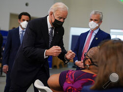 President Joe Biden talks to a person receiving a COVID-19 vaccination shot as he visits a vaccination site at Virginia Theological Seminary, Tuesday, April 6, 2021, in Alexandria, Va. (AP Photo/Evan Vucci)