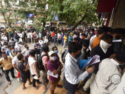 People wait in queues outside the office of the Chemists Association to demand necessary supply of the anti-viral drug Remdesivir, in Pune, India, Thursday, April 8, 2021. India is amid its worst pandemic surge, with over 100,000 cases in the past 24 hours. And experts concur that the worst is yet to come. Hospitals across the country, particularly in western Maharashtra state, are starting to get overwhelmed with patients. (AP Photo)