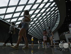 People wearing face masks to help curb the spread of the coronavirus visit a shopping mall in Beijing, Sunday, June 6, 2021. (AP Photo/Andy Wong)