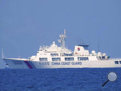 In this photo provided by the Philippine Coast Guard, a Chinese Coast Guard vessel is seen patrolling in the South China Sea, taken sometime April 13-14, 2021. Chinese coast guard ships blocked and used water cannons on two Philippine supply boats heading to a disputed shoal occupied by Filipino marines in the South China Sea, provoking an angry protest against China and a warning from the Philippine government that its vessels are covered under a mutual defense treaty with the U.S., Manila’s top diplomat s