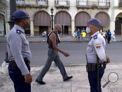 Police stand guard near the National Capitol building in Havana, Cuba, Monday, July 12, 2021, the day after protests against food shortages and high prices amid the coronavirus crisis. (AP Photo/Ismael Francisco)