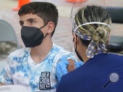 Andres Veloso, 12, gets the first dose of the Pzifer COVID-19 vaccine, Monday, Aug. 9, 2021, in Miami. Florida is reporting a surge of COVID-19 cases caused by the highly contagious delta variant. (AP Photo/Marta Lavandier)