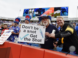 Fans holds signs during the first half of an NFL football game between the Buffalo Bills and the Pittsburgh Steelers in Orchard Park, N.Y., Sunday, Sept. 12, 2021. (AP Photo/Adrian Kraus)
