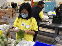 A volunteer packs onions in the warehouse of the Alameda County Community Food Bank in Oakland, Calif., on Nov. 5, 2021. U.S. food banks dealing with increased demand from families sidelined by the pandemic now face a new challenge – surging food prices and supply chain issues. As holidays approach, some food banks worry they won't have enough turkeys, stuffing and cranberry sauce for Thanksgiving and Christmas. Residents picking up free groceries in Oakland said they're grateful for the extra help as the p
