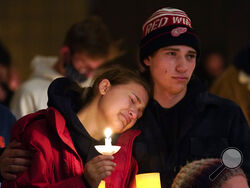 People attending a vigil embrace at LakePoint Community Church in Oxford, Mich., Tuesday, Nov. 30, 2021. Authorities say a 15-year-old sophomore opened fire at Oxford High School, killing several students and wounding multiple other people, including a teacher. (AP Photo/Paul Sancya)