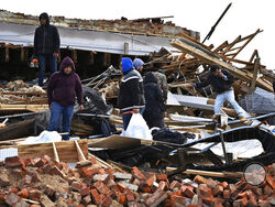 A family digs through the remains of their apartment in Mayfield, Ky., Saturday, Dec. 11, 2021. Tornadoes and severe weather caused catastrophic damage across multiple states late Friday, killing several people overnight. (AP Photo/Timothy D. Easley)