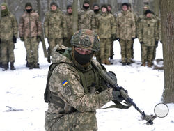 An instructor trains members of Ukraine's Territorial Defense Forces, volunteer military units of the Armed Forces, in a city park in Kyiv, Ukraine, Saturday, Jan. 22, 2022. Dozens of civilians have been joining Ukraine's army reserves in recent weeks amid fears about Russian invasion. (AP Photo/Efrem Lukatsky)