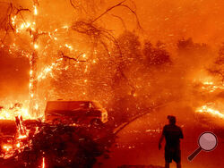 FILE - Bruce McDougal watches embers fly over his property as the Bond Fire burns through the Silverado community in Orange County, Calif., on Dec. 3, 2020. The United Nations on Monday, Feb. 28, 2022, released a new report on climate change. (AP Photo/Noah Berger, File)