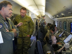 Admiral John C. Aquilino, left, Commander of the U.S. Indo-Pacific Command (INDOPACOM), looks at videos of Chinese structures and buildings on board a US P-8A Poseidon reconaisance plane flying at the Spratlys group of islands in the South China Sea on Sunday March 20, 2022. A U.S. Navy plane carrying a top American military commander was threatened repeatedly by radio on Sunday to leave the airspace over Chinese-occupied island garrisons in the disputed South China Sea, but the aircraft pressed on defiantl