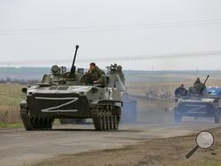 Russian military vehicles move on a highway in an area controlled by Russian-backed separatist forces near Mariupol, Ukraine, Monday, April 18, 2022. Mariupol, a strategic port on the Sea of Azov, has been besieged by Russian troops and forces from self-proclaimed separatist areas in eastern Ukraine for more than six weeks. (AP Photo/Alexei Alexandrov)