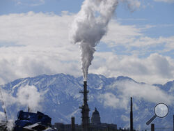 FILE - The Utah State Capitol, rear, is shown behind an oil refinery on Thursday, May 12, 2022, in Salt Lake City. President Joe Biden is promising “strong executive action” to combat climate change, despite dual setbacks that have restricted his ability to regulate carbon emissions and boost clean energy such as wind and solar power. (AP Photo/Rick Bowmer, File)
