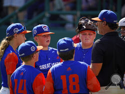 Hagerstown, Ind. manager Patrick Vinson, right, talks with his team on the mound during the second inning of a baseball game against Hollidaysburg, Pa., at the Little League World Series in South Williamsport, Pa., Tuesday, Aug. 23, 2022. (AP Photo/Gene J. Puskar)