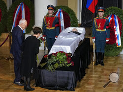 People stand by the coffin of former Soviet President Mikhail Gorbachev inside the Pillar Hall of the House of the Unions during a farewell ceremony in Moscow, Russia, Saturday, Sept. 3, 2022. Gorbachev, who died Tuesday at the age of 91, will be buried at Moscow's Novodevichy cemetery next to his wife, Raisa, following a farewell ceremony at the Pillar Hall of the House of the Unions, an iconic mansion near the Kremlin that has served as the venue for state funerals since Soviet times. (AP Photo/Alexander 