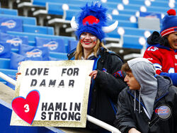 A fan holds a sign in support of Buffalo Bills safety Damar Hamlin during practices before an NFL football game against the New England Patriots, Sunday, Jan. 8, 2023, in Orchard Park, N.Y. Hamlin remains hospitalized after suffering a catastrophic on-field collapse in the team's previous game against the Cincinnati Bengals. (AP Photo/Jeffrey T. Barnes)
