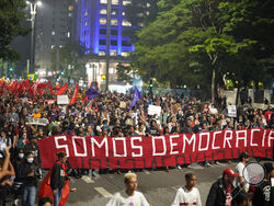 Demonstrators march holding a banner that reads in Portuguese "We are Democracy" during a protest calling for protection of the nation's democracy in Sao Paulo, Brazil, Monday, Jan. 9, 2023, a day after supporters of former President Jair Bolsonaro stormed government buildings in the capital. (AP Photo/Andre Penner)