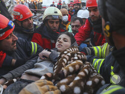 Rescuers carry Muhammed Alkanaas, 12, to an ambulance after they pulled him out five days after the Monday earthquake in Antakya, southern Turkey, late Saturday, Feb. 11. (AP Photo/Can Ozer)