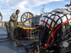 In this image released by the U.S. Navy, sailors assigned to Assault Craft Unit 4 prepare material recovered off the coast of Myrtle Beach, S.C., in the Atlantic Ocean from the shooting down of a Chinese high-altitude balloon, for transport to the FBI, at Joint Expeditionary Base Little Creek in Virginia Beach, Va., on Feb. 10, 2023. The federal government's lack of information about four aerial objects recently shot down over North America is helping to fuel conspiracy theories and conjecture on the intern