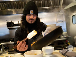 Santos Enrique Camara, 27, who dropped out of Shoreline Community College at age 19 in 2015, prepares food at Capers + Olives Friday, March 24, 2023, in Everett, Wash. where he works as a sous-chef and cook. Advocates for community colleges defend them as the underdogs of America’s higher education system, left to serve the students who need the most support but without the money to provide it. Critics contend this has become an excuse for poor success rates and for the kind of faceless bureaucracies that u
