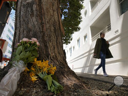 A woman walks past flowers left outside an apartment building where a technology executive was fatally stabbed in San Francisco, Wednesday, April 5, 2023. Bob Lee, a technology executive who created Cash App and was currently chief product officer of MobileCoin, was fatally stabbed in San Francisco early Tuesday, April 4, 2023, according to the cryptocurrency platform and police. (AP Photo/Eric Risberg)